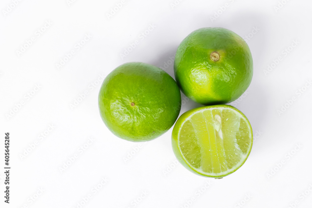 Green lime, sliced in half spokes on a white background, the view from the top. Green lime, sliced in half spokes on a white background, the view from the top.