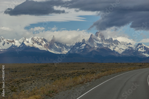 sphalted road with the peaks of a rocky and snowy mountain on the horizon. Fitz Roy mountain in Argentina horizontal Photograph