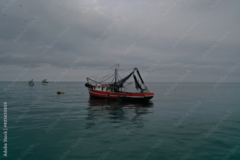 Aerial view of a medium sized fishing boat towards the shoreline of Puerto lopez