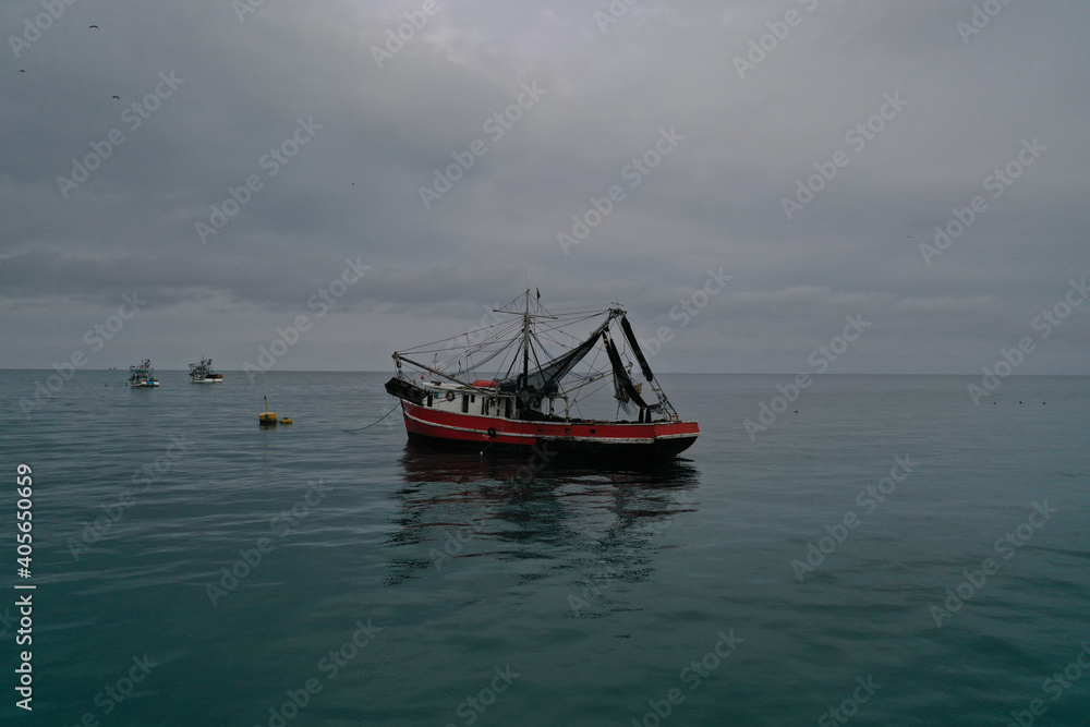 Aerial view of a medium sized fishing boat towards the shoreline of Puerto lopez Aerial view of a medium sized fishing boat towards the shoreline of Puerto lopez
