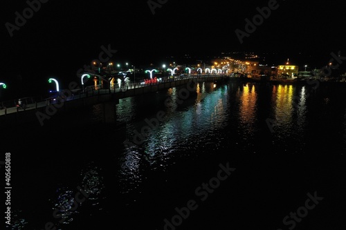 A bridge over a large river illuminated with white lights © pangamedia