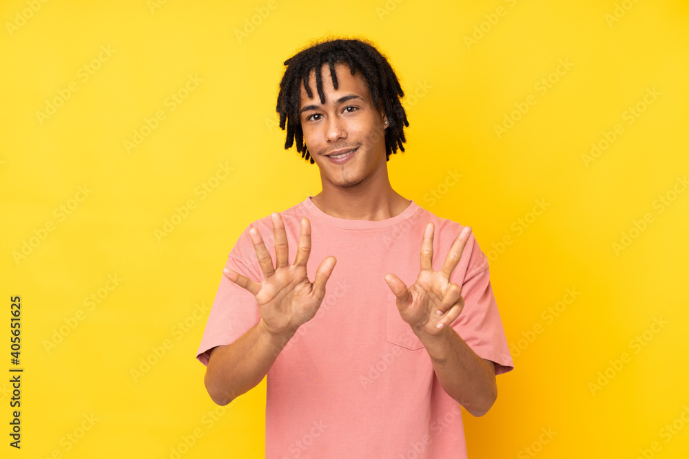 Young african american man isolated on yellow background counting eight with fingers Young african american man isolated on yellow background counting eight with fingers