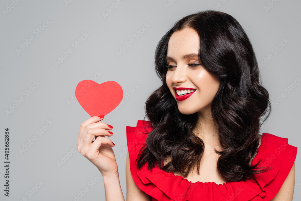 cheerful young woman holding red paper heart isolated on grey cheerful young woman holding red paper heart isolated on grey