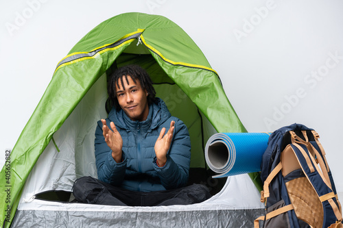 Young african american man inside a camping green tent applauding after presentation in a conference