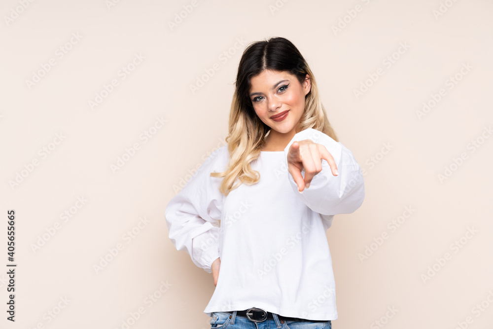 Teenager girl isolated on beige background showing and lifting a finger Teenager girl isolated on beige background showing and lifting a finger