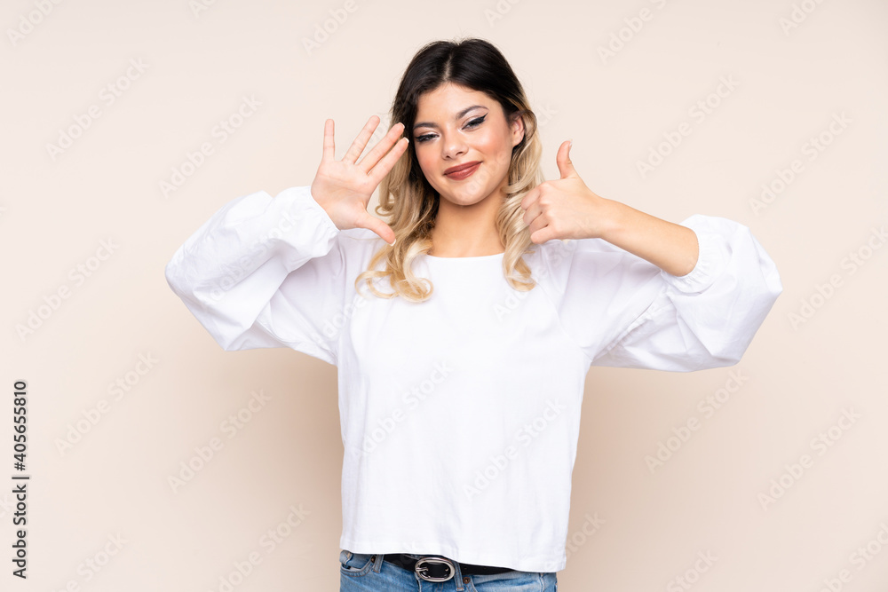 Teenager girl isolated on beige background counting six with fingers Teenager girl isolated on beige background counting six with fingers