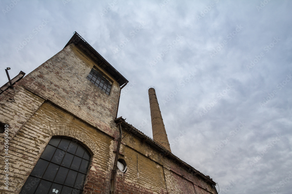 Abandoned factory and warehouse with its distinctive brick chimney in Eastern Europe, in Belgrade Serbia, former Yugoslavia, during a cloudy afternoon Abandoned factory and warehouse with its distinctive brick chimney in Eastern Europe, in Belgrade Serbia, former Yugoslavia, during a cloudy afternoon