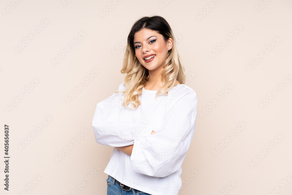 Teenager girl isolated on beige background with arms crossed and looking forward Teenager girl isolated on beige background with arms crossed and looking forward
