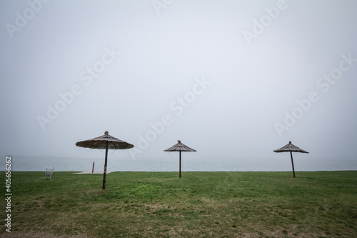 Smoggy fog in winter on the Palic Lake, in Subotica, Serbia, while sun umbrella parasols are visible. Also known as Palicko Jezero, it is one of the main attractions of Vojvodina province photo