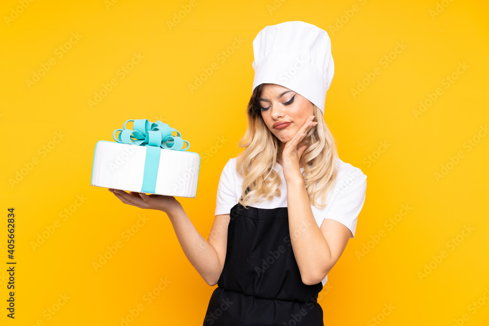 Teenager girl pastry holding a big cake isolated on yellow background unhappy and frustrated Teenager girl pastry holding a big cake isolated on yellow background unhappy and frustrated