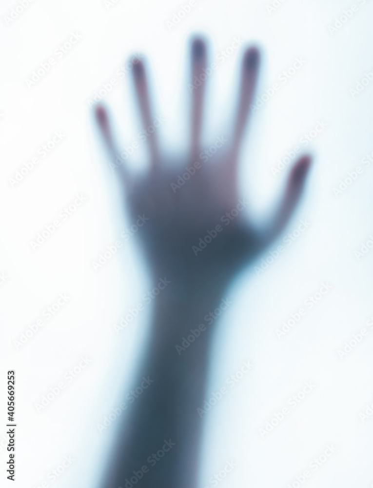 Photo of a blurred paranormal human ghost hand on white background.