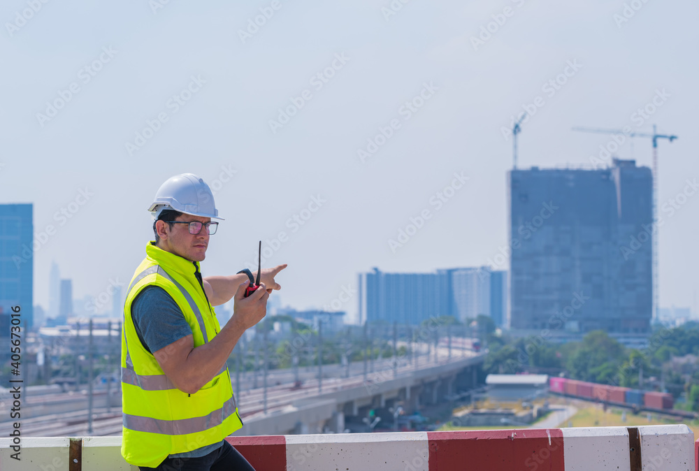 Portrait engineer under inspection and checking construction process railway and checking work on railroad station .Engineer wearing safety uniform and safety helmet in work. Portrait engineer under inspection and checking construction process railway and checking work on railroad station .Engineer wearing safety uniform and safety helmet in work.