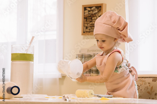 Little girl cooks at home in the kitchen