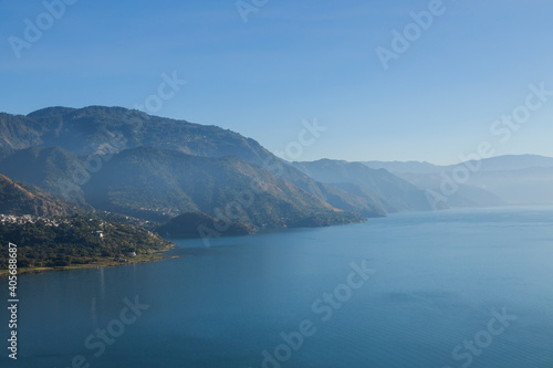Lake Atitlan in Guatemala in the morning seen from the viewpoint in San Juan la Laguna - landscape of lake surrounded by mountains with sunrise light © Fernanda