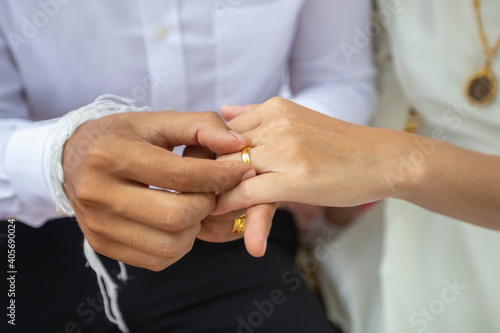 The groom is wearing a ring to the bride on the wedding day.