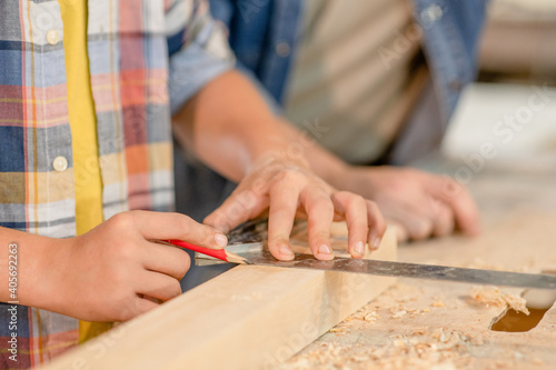 Father teaches son carpentry at a workshop