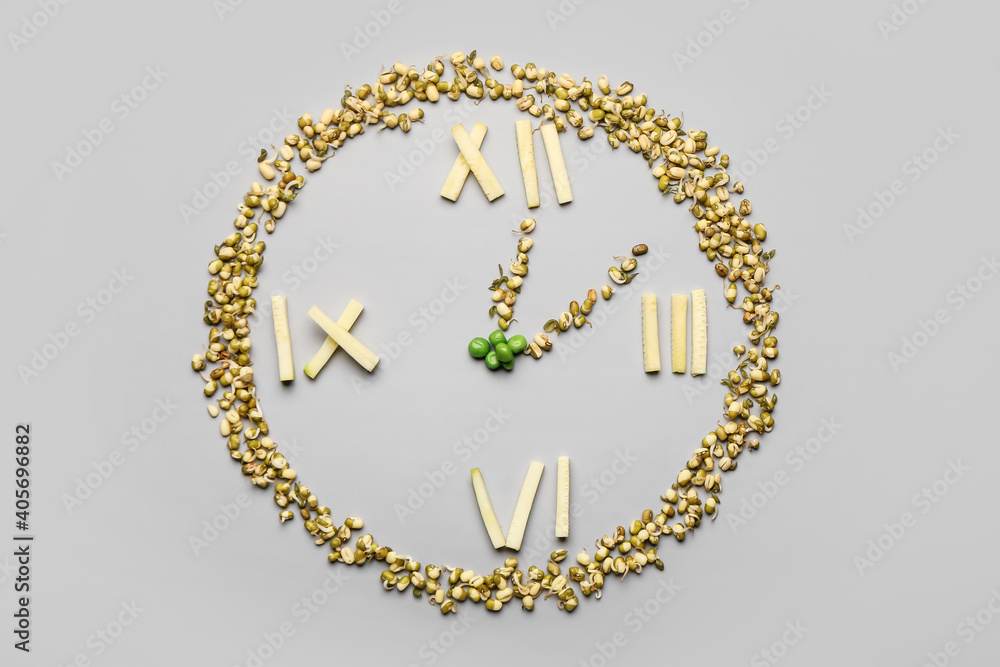 Clock made of food on grey background