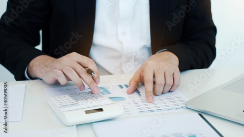 Business people working on desk and analysis about summary budget finance and using laptop making note report.