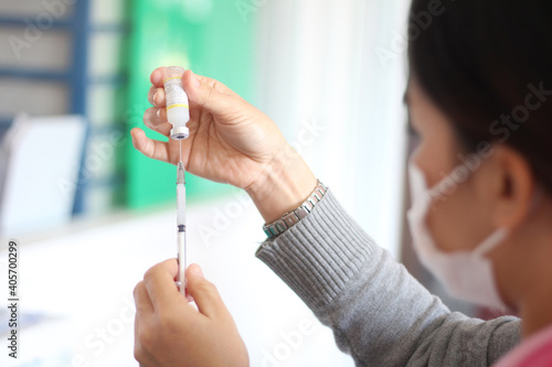 Vaccine in researcher hands  female doctor holds syringe and bottle with vaccine for coronavirus cure. Concept of corona virus treatment  injection  shot and clinical trial during pandemic.