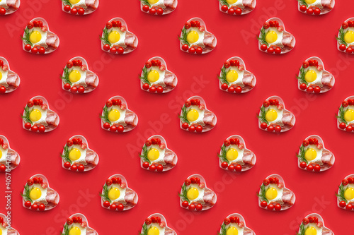 Pattern with food for Valentine's Day. A plate in the shape of a heart of roasted egg tomatoes and bacon on a red background. A seamless pattern.