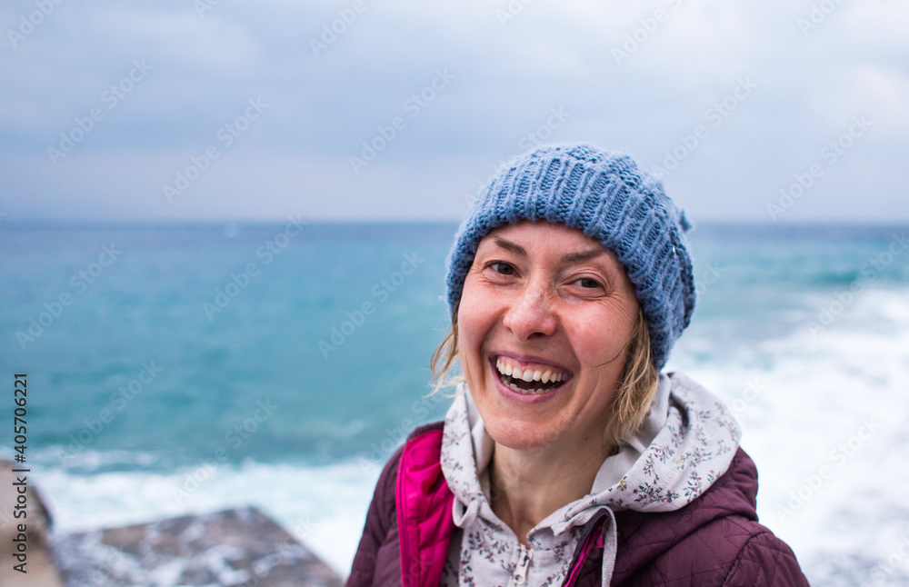 Portrait of a smiling girl in a knitted hat while walking along the sea coast Portrait of a smiling girl in a knitted hat while walking along the sea coast