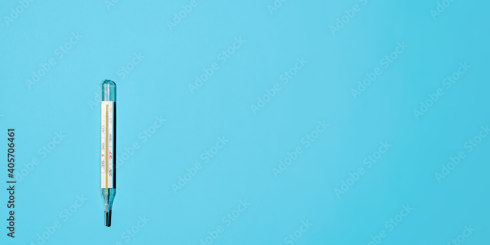 Classic Celsius thermometer on a light blue background, flat lay. Banner, space for text on the right. Medical minimalist photo Classic Celsius thermometer on a light blue background, flat lay. Banner, space for text on the right. Medical minimalist photo