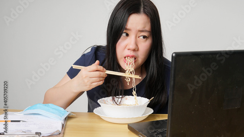 Asia women business executive eating noodle soup at her workplace