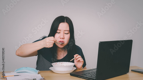 Asia women business executive eating noodle soup at her workplace