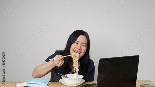 Asia women business executive eating noodle soup at her workplace