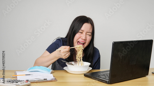 Asia women business executive eating noodle soup at her workplace
