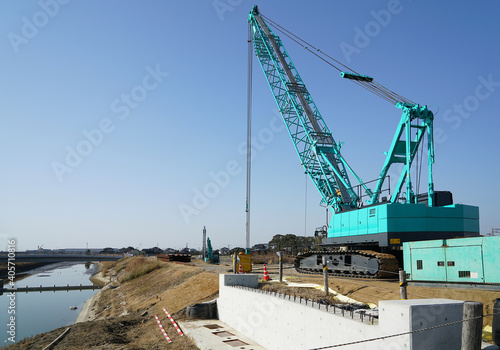 河川工事に使われるクローラクレーン　橋の架け替え工事のクレーン　河川拡張工事中のクレーン