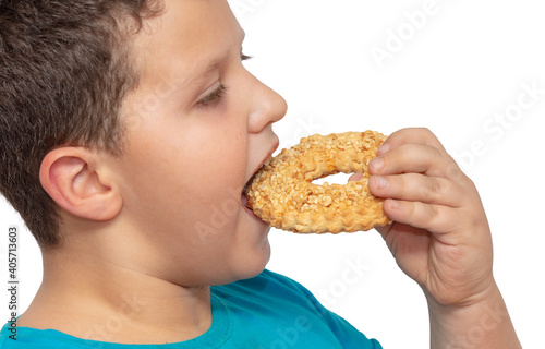 Boy eats shortbread cookies on a white