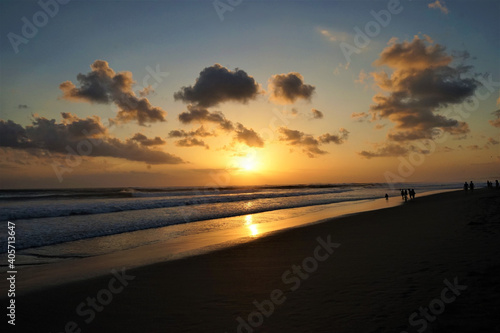 People walking on sunset beach in Seminyak  Bali  Indonesia