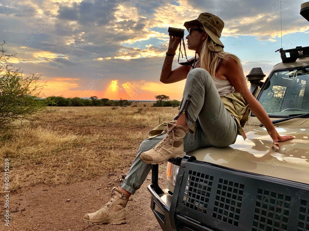 Woman On Vehicle Field Against Sky During Sunset - obrazy, fototapety, plakaty 