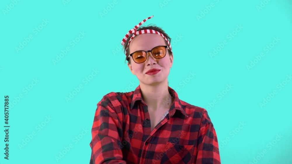 Beautiful woman dressed in pin-up style flirting, wearing fashionable glasses on blue, isolate. Seduction concept. Beautiful woman flirting with camera. Beautiful woman dressed in pin-up style flirting, wearing fashionable glasses on blue, isolate. Seduction concept. Beautiful woman flirting with camera.