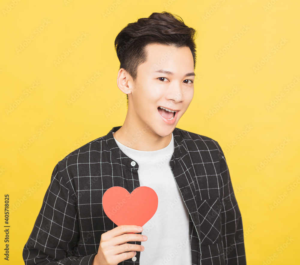 excited young man holding Valentines Day red heart sign excited young man holding Valentines Day red heart sign