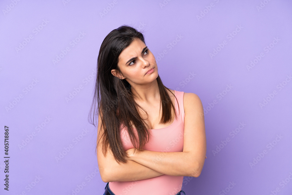 Young woman over isolated purple background making doubts gesture while lifting the shoulders Young woman over isolated purple background making doubts gesture while lifting the shoulders