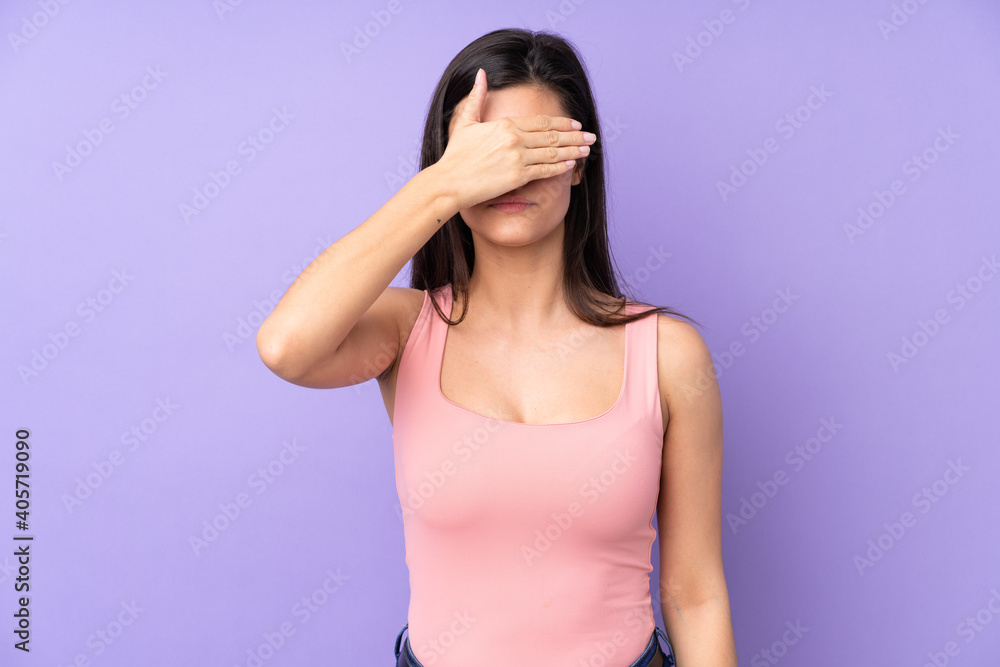 Young woman over isolated purple background covering eyes by hands. Do not want to see something Young woman over isolated purple background covering eyes by hands. Do not want to see something