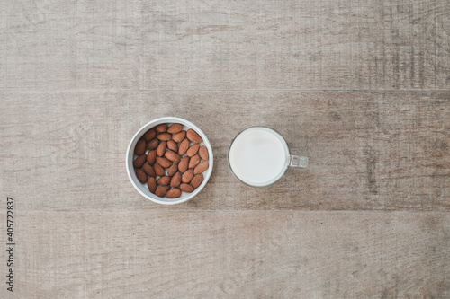 Almond milk in glass with almonds on wooden table. Selective focus