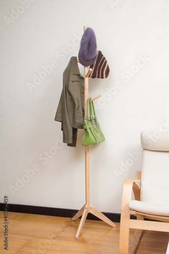 Принти на полотні Wooden coat rack with jacket, hats and handbag in the room
