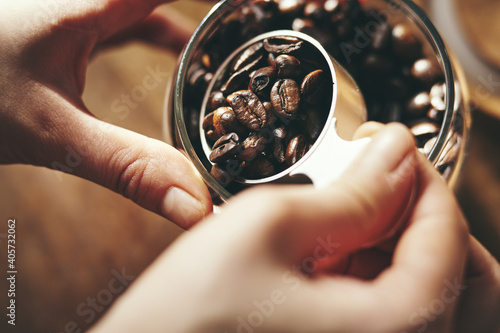 コーヒー豆を計量スプーンで計る女性の手元 photo