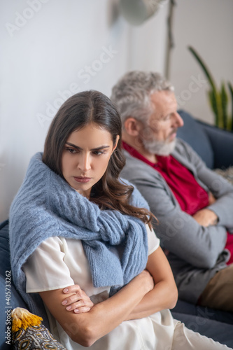 Annoyed woman sitting on a sofa near her husband