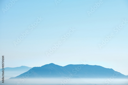 Mountain peaks surrounded by fog in the morning during the sunrise