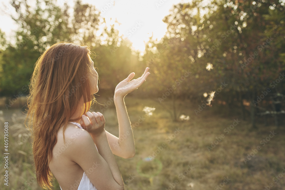 attractive woman in a white sundress resting in nature at sunset attractive woman in a white sundress resting in nature at sunset