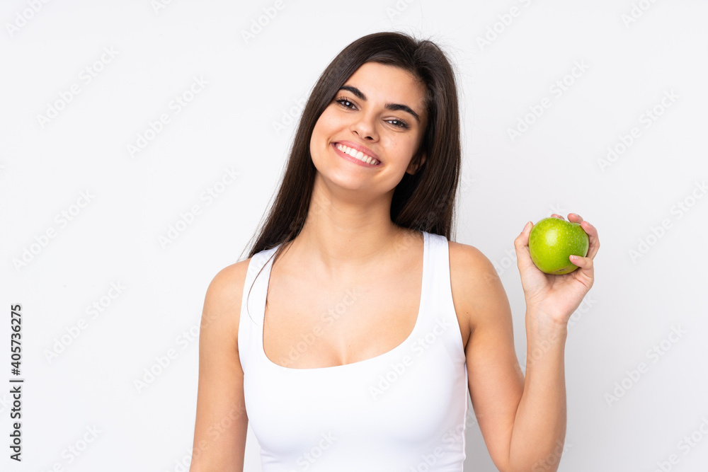 Young woman over isolated white background with an apple and happy Young woman over isolated white background with an apple and happy