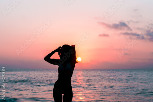 Silhouette of a girl on the beach during sunrise