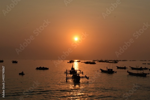 beautiful sunrise on the beach horizon with the silhouette traditional fisherman boat
