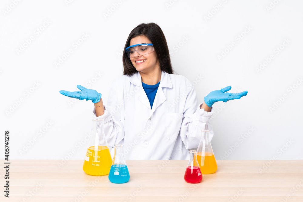 Young scientific woman in a table holding copyspace with two hands Young scientific woman in a table holding copyspace with two hands