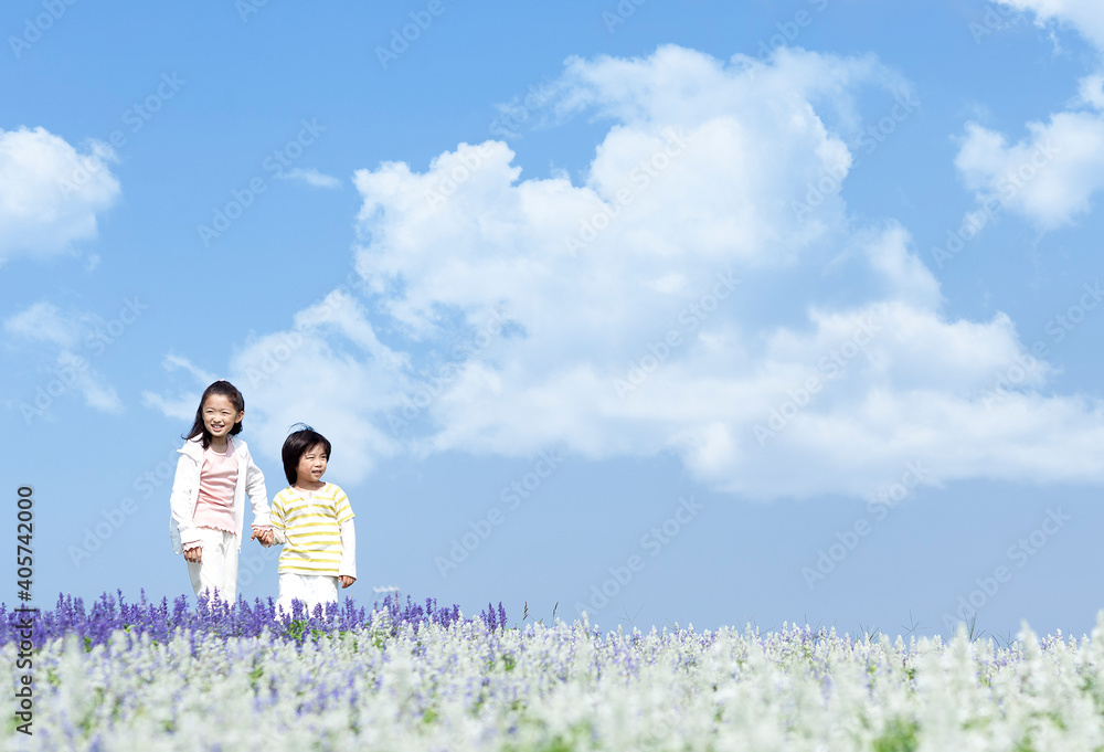 花畑を歩く女の子と男の子