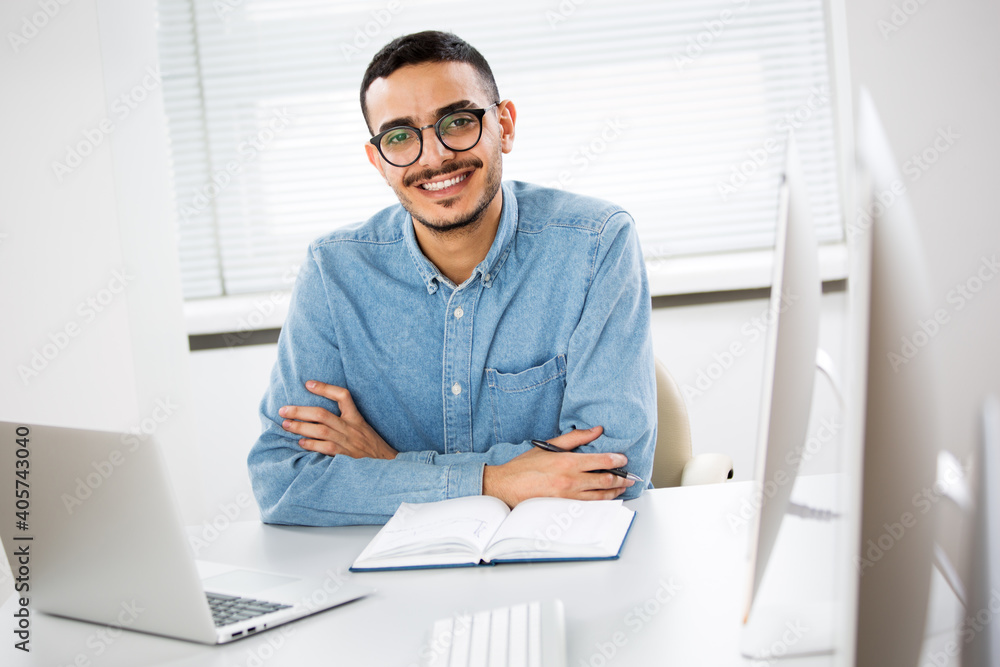Happy arab businessman smiling while looking at camera in office Happy arab businessman smiling while looking at camera in office
